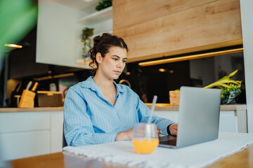 Young caucasian woman working from home on laptop