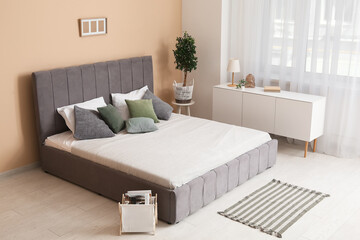 Comfortable bed and chest of drawers in bedroom