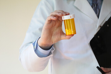Healthcare professional holding a bottle of prescription pills