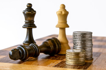 Battle chess game stand on chessboard . On chess board Money and Chess. Strategy investment with money. Concept for success. Euro coins stacked  on a chess board. (Concept for company strategy).