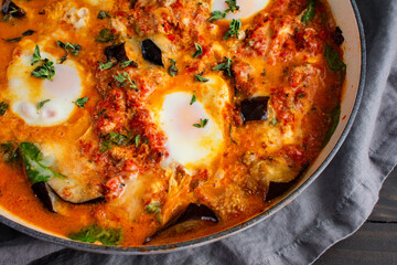 Eggplant Parmigiana Shakshuka in a Large Braising Pan: Vegetarian Italian-Middle Eastern fusion cuisine served in a large pan with a side of garlic bread