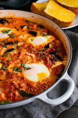 Eggplant Parmigiana Shakshuka in a Large Braising Pan: Vegetarian Italian-Middle Eastern fusion cuisine served in a large pan with a side of garlic bread