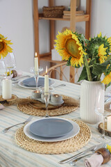 Vases with beautiful sunflowers on served table