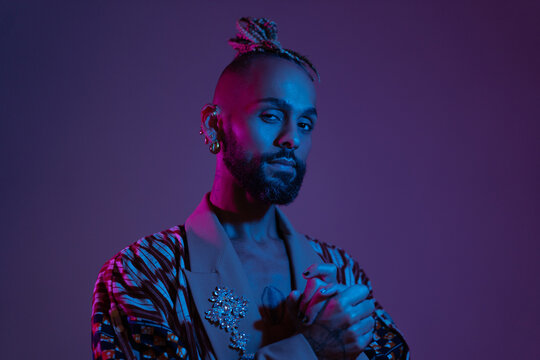 Retro wave or synth wave portrait stylish serious african-american man studio shoot. High Fashion male model in colorful bright neon lights posing. Art design concept