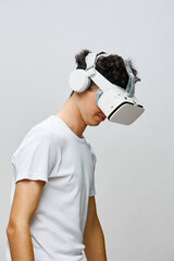 Virtual Reality Experience, Young Man with Headset, Technology and Innovation in Focus, Neutral Background, Immersive Gaming Concept, Modern Lifestyle, Futuristic Engagement