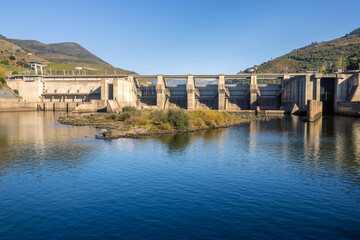 Front view of the Régua dam on the Douro River in Portugal, on a sunny day in autumn.