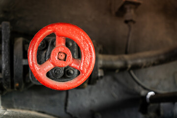 Detailed view of red valve in steam locomotive engine compartment