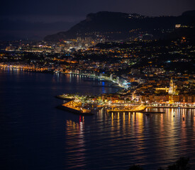 Night view on French Riviera, lights of Menton old city and marina on blue Mediterranean Sea near French-Italian border, Monaco, Monte-Carlo, travel destination, panoramic view