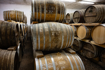 Aging process of cognac spirit in old dark French oak barrels in cellar in distillery house, Cognac white wine region, Charente, Segonzac, Grand Champagne, France