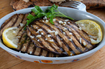 Italian style starter served in restaurant, grilled eggplant with garlic, olive oil and fresh parsley