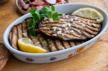 Italian style starter served in restaurant, grilled eggplant with garlic, olive oil and fresh parsley