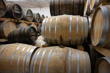 Aging process of cognac spirit in old dark French oak barrels in cellar in distillery house, Cognac white wine region, Charente, Segonzac, Grand Champagne, France