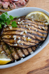 Italian style starter served in restaurant, grilled eggplant with garlic, olive oil and fresh parsley