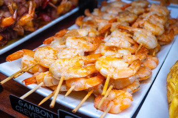 Typical snacks of Basque Country, pinchos or pinxtos skewers with small pieces of bread, fish, sea food, sweet green pepper served in bar in San-Sebastian or Bilbao, Spain