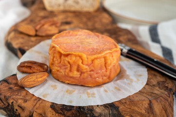 Rond des Vignes washed-rind cheese with.ivory-orange rind, strong nose with aromas, French soft cheese with orange rind