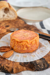 Rond des Vignes washed-rind cheese with.ivory-orange rind, strong nose with aromas, French soft cheese with orange rind