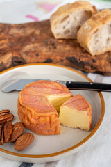 Rond des Vignes washed-rind cheese with.ivory-orange rind, strong nose with aromas, French soft cheese with orange rind