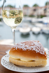 Wine and cakes of French Riviera, glasses of cold white Cote de Provence wine and Tarte Tropezienne cake in yacht harbour of Port Grimaud, summer vacation in Provence, France