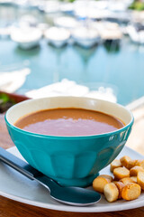 Homemade tasty fish or bisque soup with croutons and view on yacht boats and houses of Port Grimaud, French Riviera, France. Food of Provence