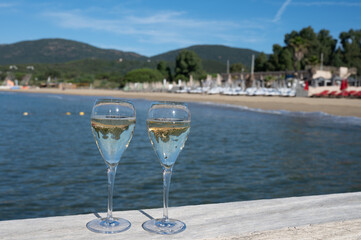 Summer time in Provence, two glasses of cold champagne cremant sparkling wine on famous Pampelonne sandy beach near Saint-Tropez in sunny day, Var department, France, beach club party