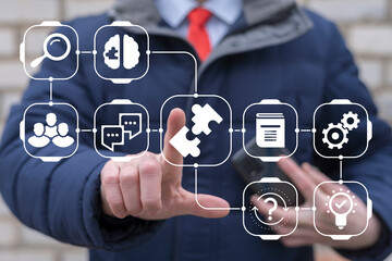 Business man touched jigsaw puzzle icon on virtual touch screen. Business, strategy, education, teamwork, innovative ideas concept. Soft skills for business. Work together joining.