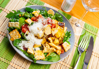 Delicious fresh caesar salad with parmesan and sliced chicken served on plate
