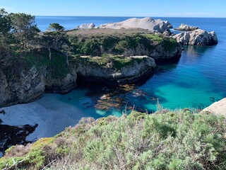 Pristine cove with crystal blue water and white sand beach in Point Lobos State Natural Preserve, California