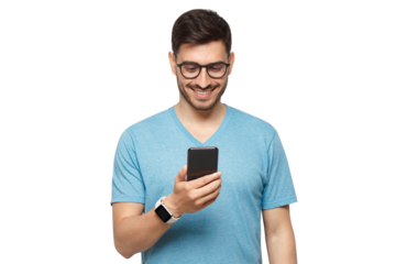 Young handsome man in blue t-shirt holding smartphone and looking at phone screen with smile while standing