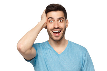 Young happy excited man in blue t-shirt, touching his head with amazement, trying to believe in his success