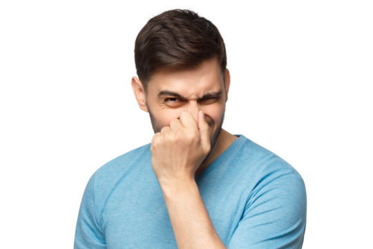 Young man holding his nose as smelling something rotten and stinky, trying to find source of odor