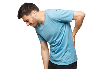 Young unhappy guy in blue t-shirt suffering from severe backache, touching back trying to ease pain...