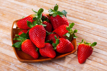 Sweet juicy strawberries served on platter to table in cafe
