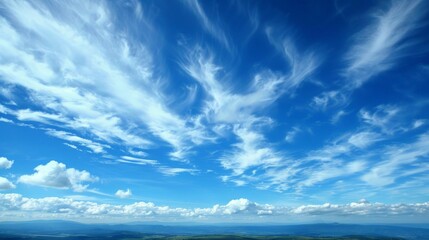 Obraz premium Clouds drift lazily across the azure expanse, painting ever-changing patterns in the sky.