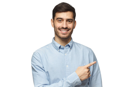 Smiling businessman pointing right with index finger and looking at camera