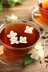 Hot jasmine tea in cups and flowers on wooden table