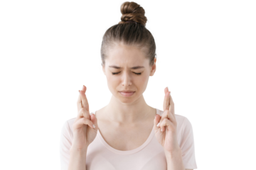 Worried young woman with fingers crossed, eyes closed, hoping or wishing for good luck