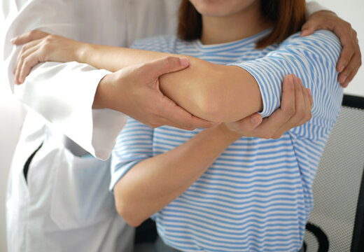 Asian female patient doing physical therapy with physical therapist Perform pain therapy in a hospital