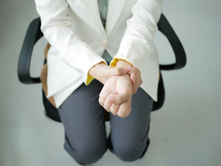 A young businesswoman has severe pain in her wrist. She has numbness. She massages her arm by...