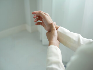 A young businesswoman has severe pain in her wrist. She has numbness. She massages her arm by...