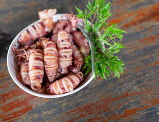 Stir-fried squid and egg in a bowl behind a wooden floor Leave the copy space.