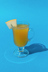 Refreshing Summer Drink with Lime Slice in a Clear Glass on Bright Blue Background