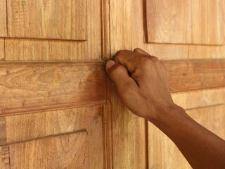 Close-up of someone's hand knocking on the door