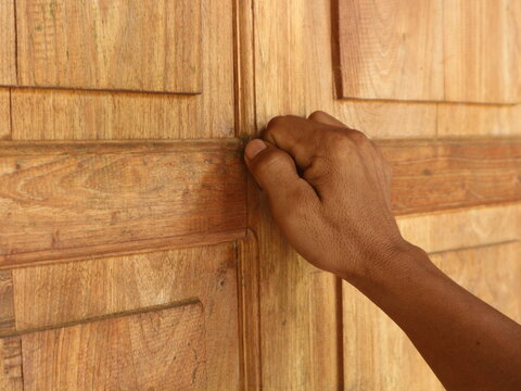 Close-up of someone's hand knocking on the door
