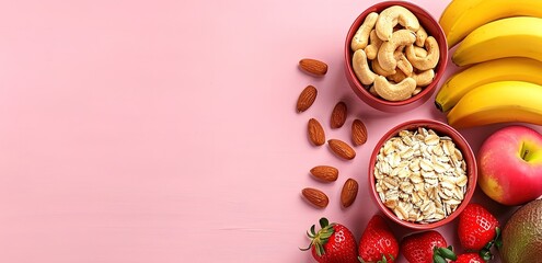 Two wooden bowls of almonds and oats with bananas, apples, and stawberries and almonds on a pink background