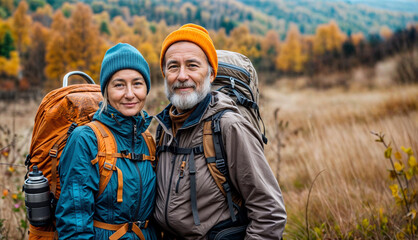 Senior couple hike. Two old happy people walk. Autumn nature with mature woman and man hiking together. Healthy active family lifestyle. Sport travel in autumn mountain landscape. Outside adventure