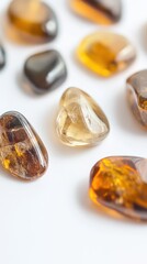 A collection of polished amber stones showcases their natural beauty and varying hues against a white backdrop