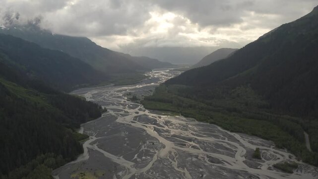 Aerial view of Exit Glacier river landscape with mountains and clouds during sunset near Kenai Fjords National Park in Seward, Alaska - 4K Drone