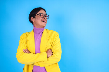 Cheerful Asian Man in Vibrant Clothes Looking Up Isolated on Blue Background