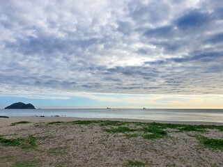 Turquoise waters kiss a pristine sandy shore, framed by swaying palms under a vibrant summer sky