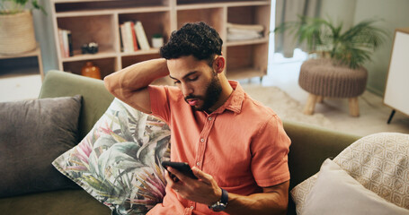 Man, phone and stress in home with mistake, loss and online gambling with debt on couch in living room. Person, smartphone and worry with risk, frustrated and confused with mobile app in Colombia